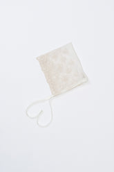 Avauma Clare Bonnet - Ivory Race, laid flat on white background to display floral embroidery and ribbon ties